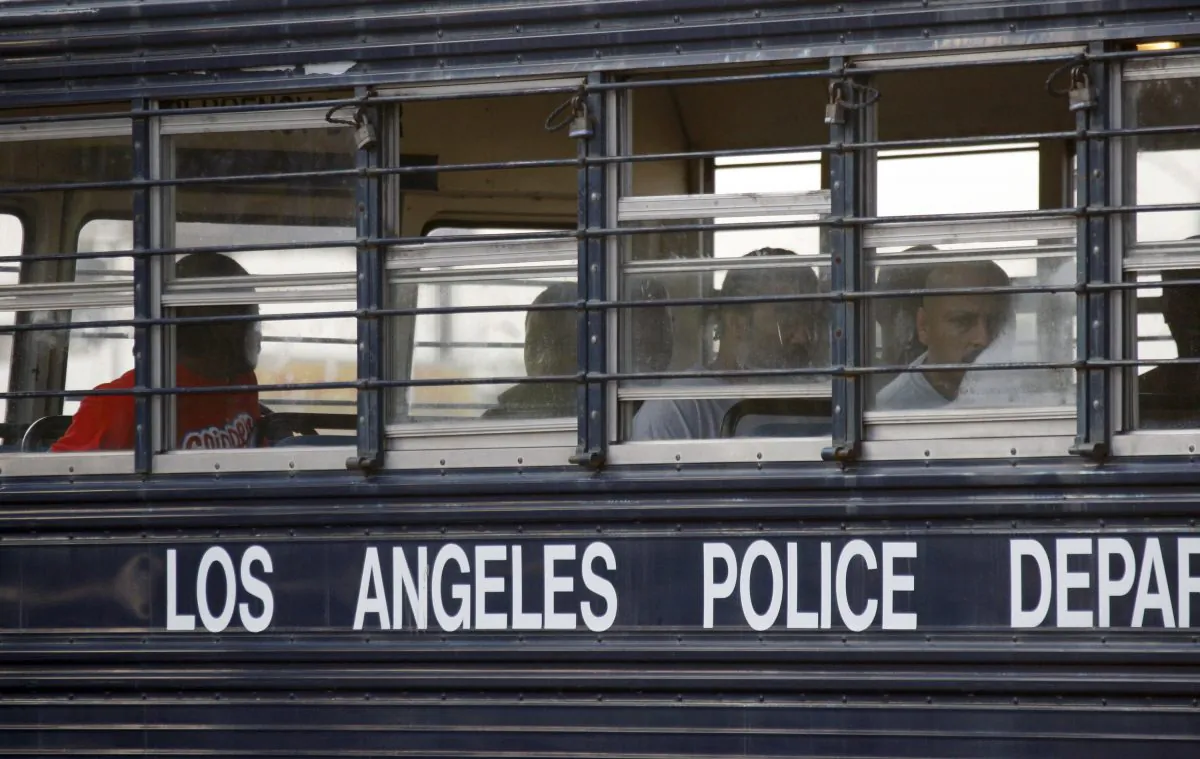 Suspected gang members sit in a bus after their arrest by members of a task force from the Los Angeles police department and the FBI in Los Angeles on May 19, 2011. (AP Photo/Nick Ut)
