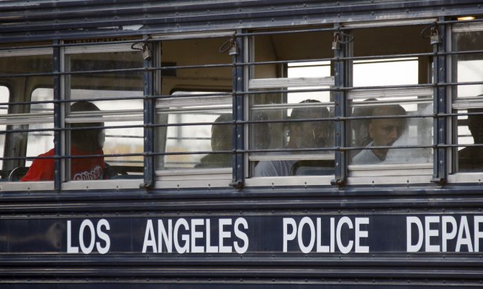 Suspected gang members sit in a bus after their arrest by members of a task force from the Los Angeles police department and the FBI in Los Angeles on May 19, 2011. (AP Photo/Nick Ut)