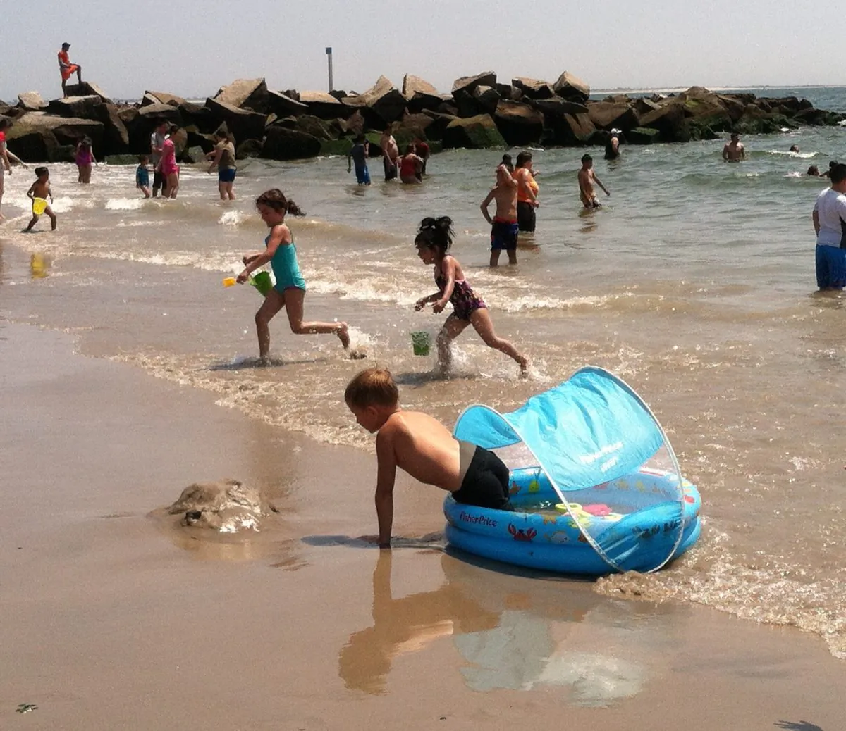 Children play at the Coney Island beach in Brooklyn on Wednesday, July, 23, 2014. After 10 year-old Takara McDuffy drowned on Tuesday evening at the beach, Brooklyn borough president Eric Adams announced efforts to pass legislation requiring water safety education in all city public schools. (Annie Wu/Epoch Times)