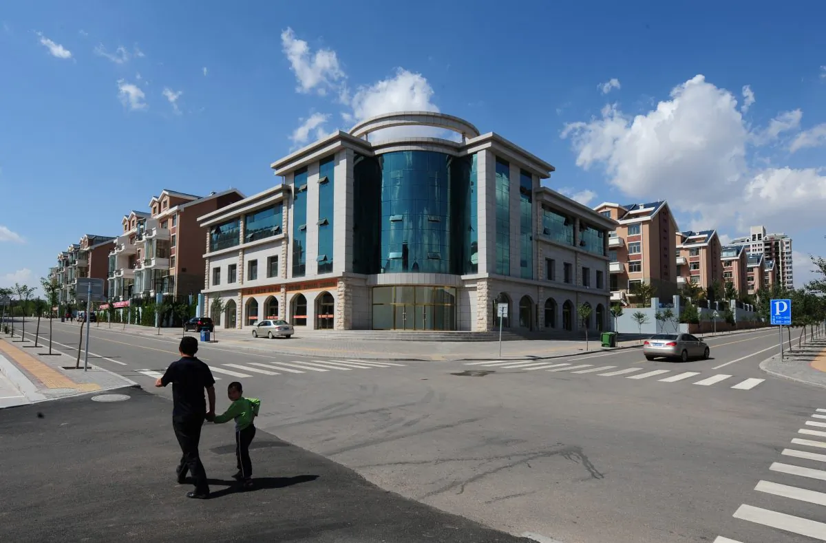 People walk past empty apartment buildings and streets in the "ghost city" of Ordos, Inner Mongolia, Sept. 12, 2011. (Mark Ralston/AFP/Getty Images)