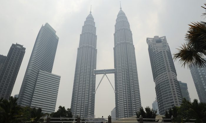 Malaysia's landmark Petronas Twin Towers (C) are covered with light haze in Kuala Lumpur on July 23, 2013. An incident involving diplomatic immunity has caused an uproar in both Malaysia and New Zealand. (Mohd Rasfan/AFP/Getty Images)
