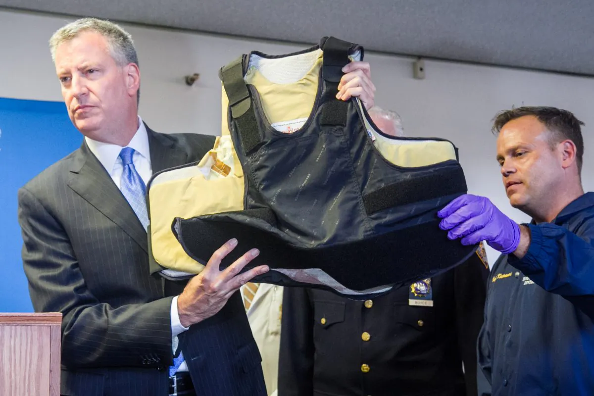 New York City Mayor Bill de Blasio holds a bullet proof vest at the Bellevue Hospital Center worn by the NYPD detective who was shot earlier today along with two U.S. Marshals, by sex-assault suspect Charles Mozdir, 32, in the West Village, New York City, on Monday, July 28, 2014. (Benjamin Chasteen/Epoch Times)
