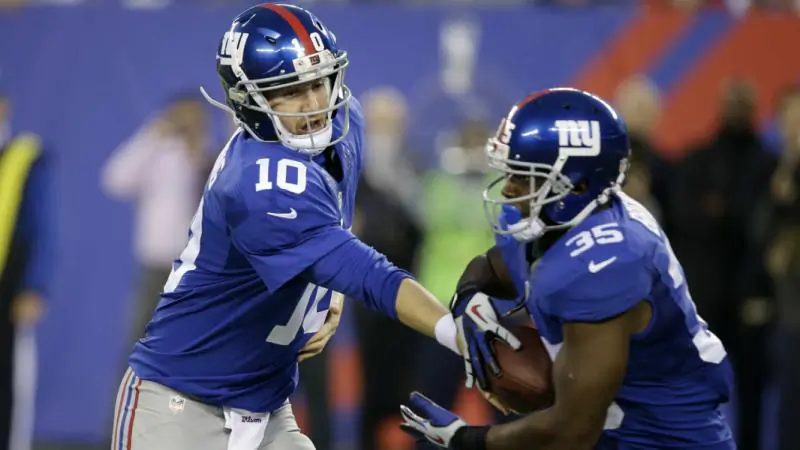 Giants quarterback Eli Manning hands off to Andre Brown (Sporting News)