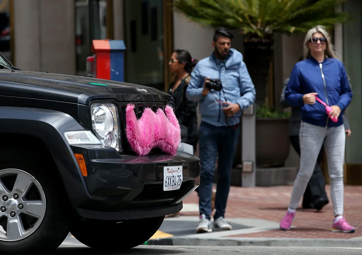 Pedestrians cross the street in front of a Lyft car in San Francisco, Calif., on June 12, 2014. (Justin Sullivan/Getty Images)