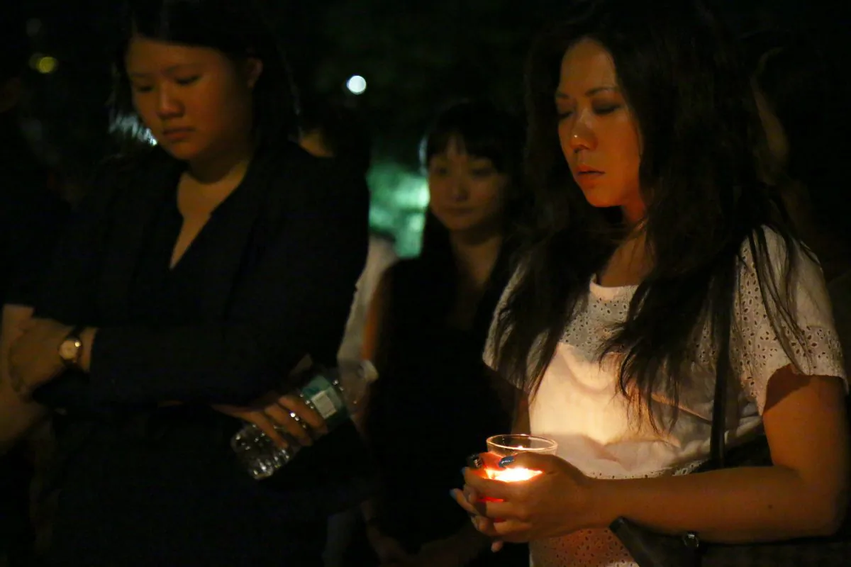Members of the local Malaysian community mourn lives lost in the flight MH17 disaster, at Washington Square Park, Manhattan, New York, July 21, 2014. (Brendon Fallon/Epoch Times)