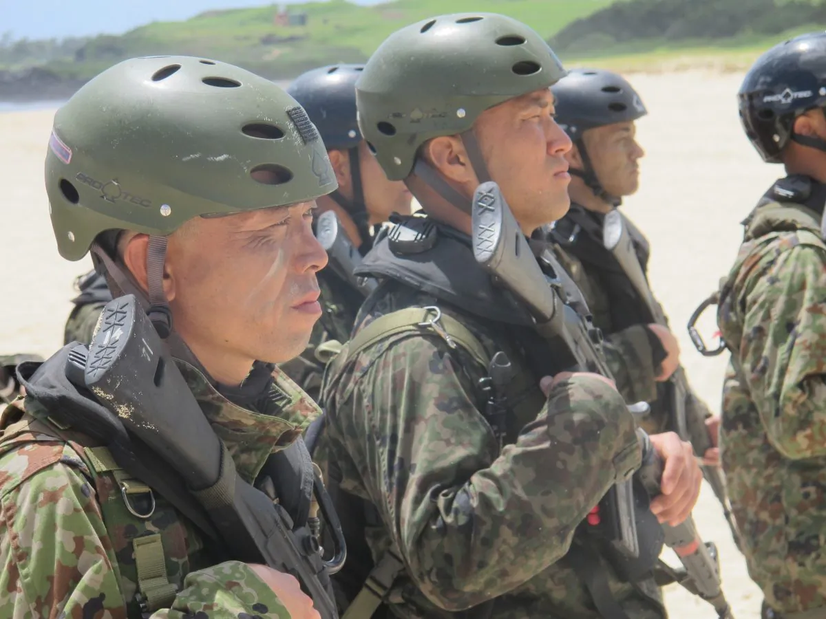 Japanese soldiers on a reconnaissance team stand at attention on the beach at Kaneohe Bay, Hawaii after amphibious landing practice on Tuesday, July 29, 2014. The amphibious landing exercises, which are relatively new to Japan’s military, come as Tokyo tries to boost its ability to defend small islands it controls but China claims as its own. (AP Photo/Audrey McAvoy)