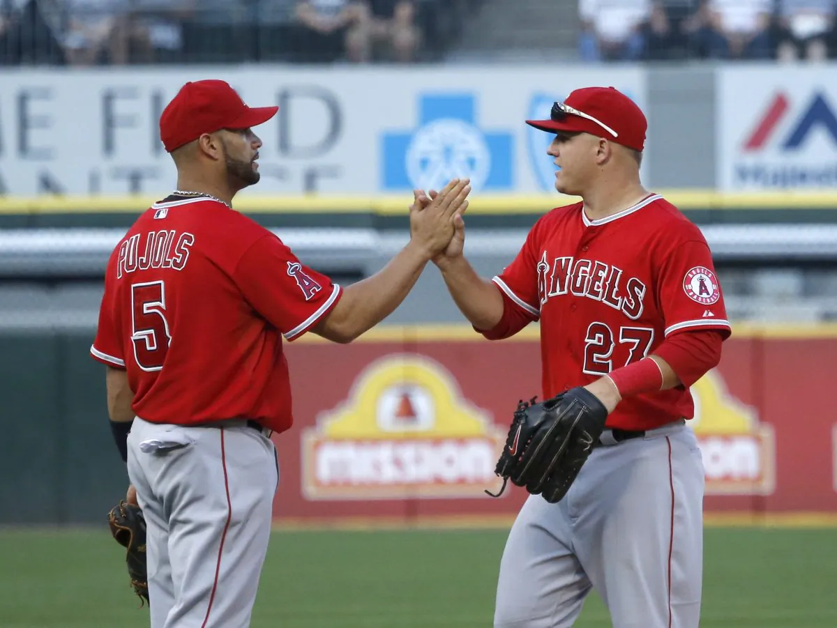 Los Angeles Angels center fielder Mike Trout (27) and Albert Pujols celebrate the Angels' 8-4 win over the Chicago White Sox after a baseball game Tuesday, July 1, 2014, in Chicago. (AP Photo/Charles Rex Arbogast)