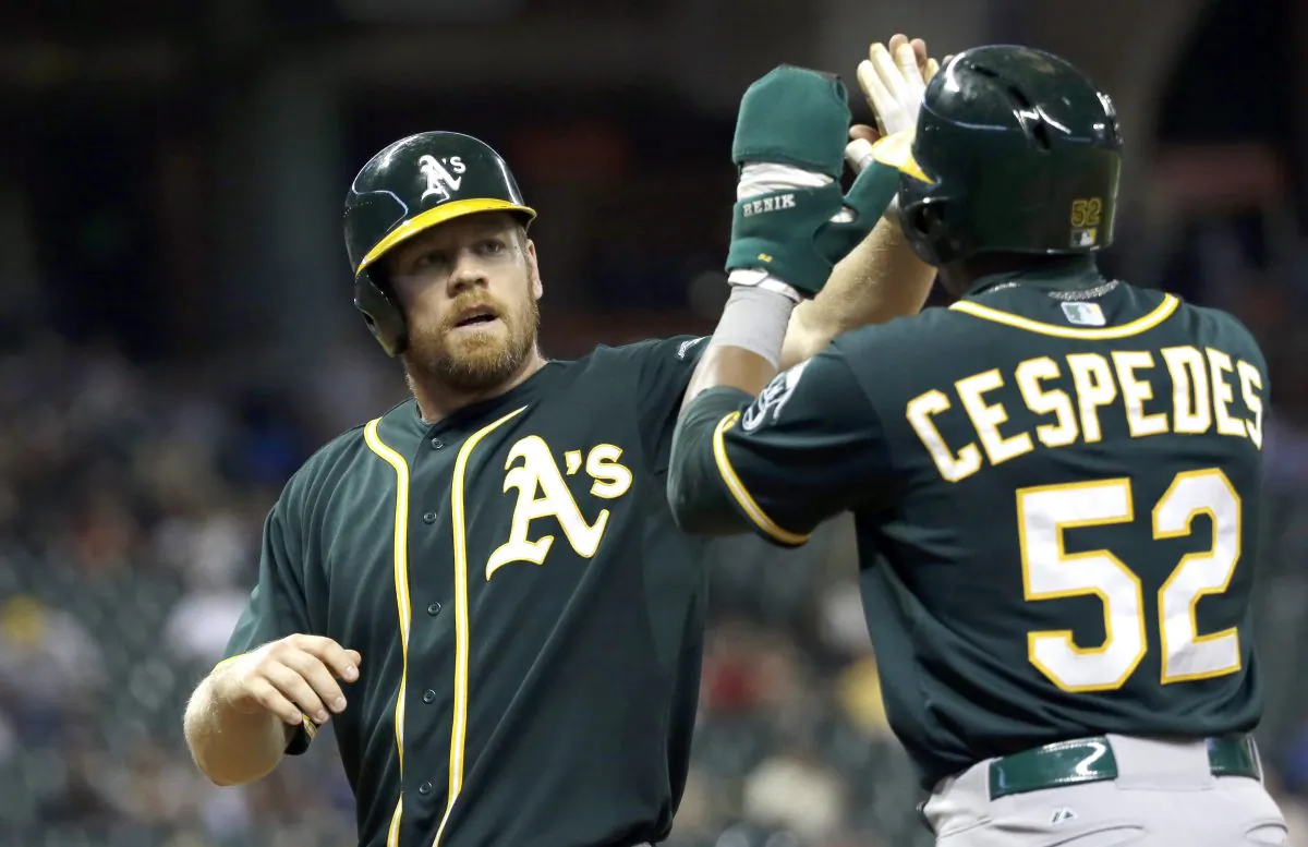 Oakland Athletics' Brandon Moss, left, and Yoenis Cespedes celebrate after scoring on Josh Donaldson's double during the ninth inning of a baseball game against the Houston Astros  Tuesday, July 29, 2014, in Houston. The Athletics beat the Astros 7-4. (AP Photo/David J. Phillip)