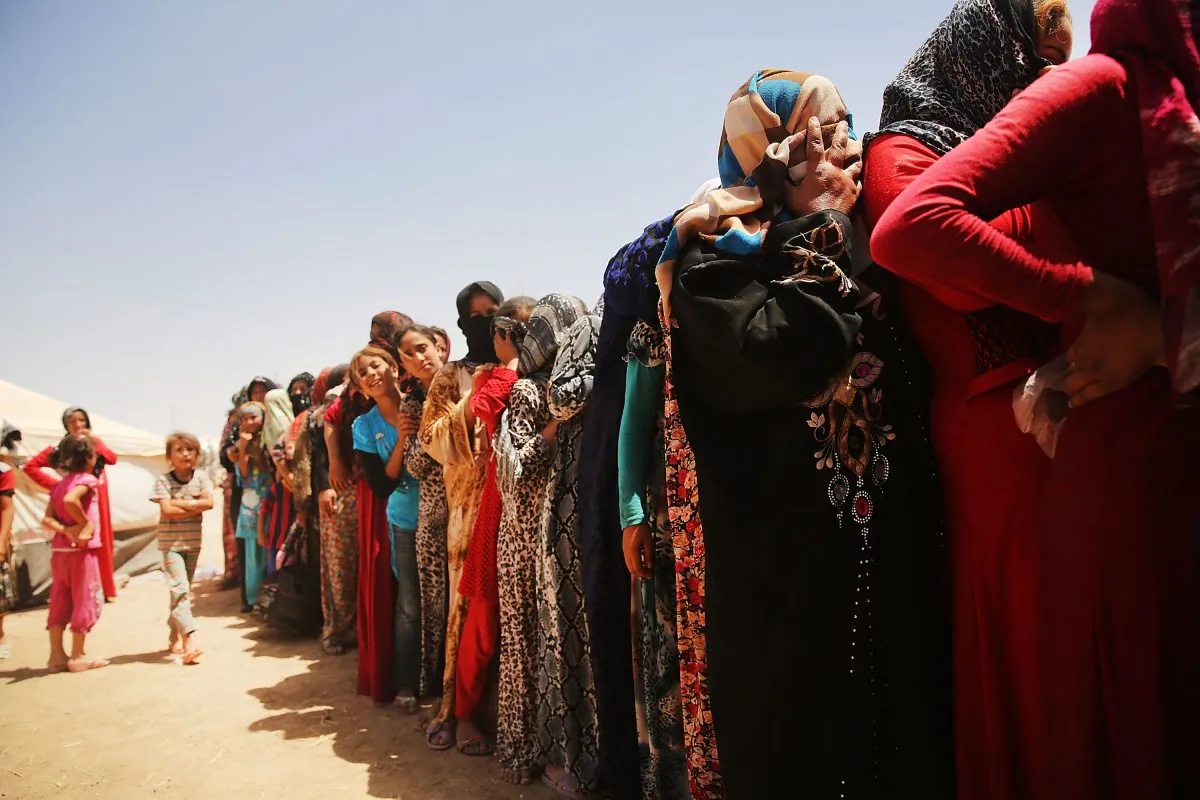 Desperate Iraqi women at the Khazair displacement camp for those caught-up in the fighting in and around the city of Mosul, wait for food and other items being dispensed by the Iraqi Red Crescent society on June 30, 2014 in Khazair, Iraq. Khazair is now home to an estimated 1,500 internally displaced persons (IDP's) with the number rising daily. Tens of thousands of people have fled Iraq's second largest city of Mosul after it was overrun by ISIS (Islamic State of Iraq and Syria) militants. Many have been temporarily housed at various IDP camps around the region including the area close to Erbil, as they hope to enter the safety of the nearby Kurdish region. (Spencer Platt/Getty Images)