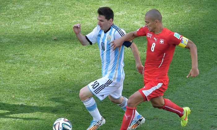 Argentina's forward and captain Lionel Messi (L) is challenged by Switzerland's midfielder and captain Goekhan Inler during the second half of a Round of 16 football match between Argentina and Switzerland at Corinthians Arena in Sao Paulo during the 2014 FIFA World Cup on July 1, 2014. (Gabriel Bouys/AFP/Getty Images)