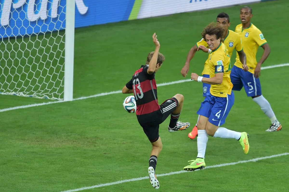 Germany's forward Thomas Mueller (L) scores his team's first goal during the semi-final football match between Brazil and Germany at The Mineirao Stadium in Belo Horizonte during the 2014 FIFA World Cup on July 8, 2014. (GABRIEL BOUYS/AFP/Getty Images)