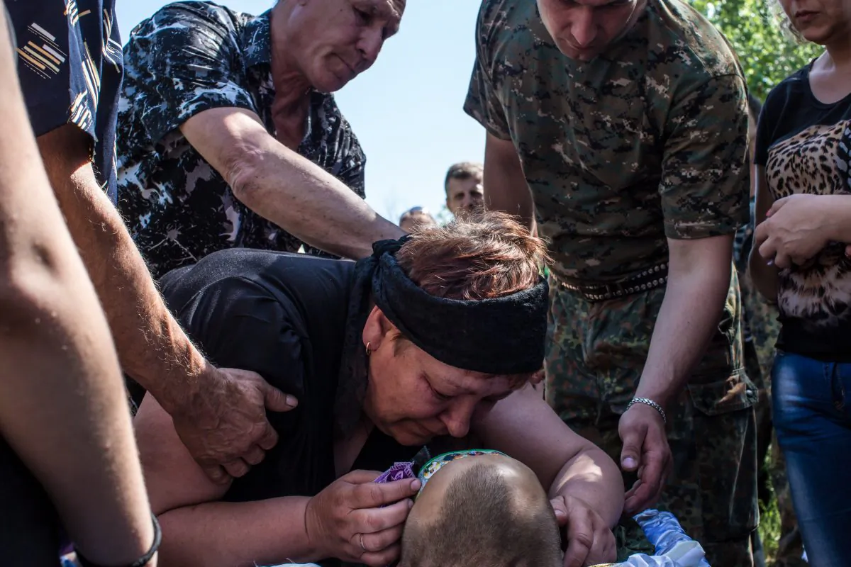 Relatives grieve over the body of Aleksandr Politov, a pro-Russia militia fighter who was killed when his group attacked a Ukrainian military checkpoint two days earlier in the village of Blahodatne, on May 24, 2014 in Horlivka, Ukraine. (Brendan Hoffman/Getty Images)