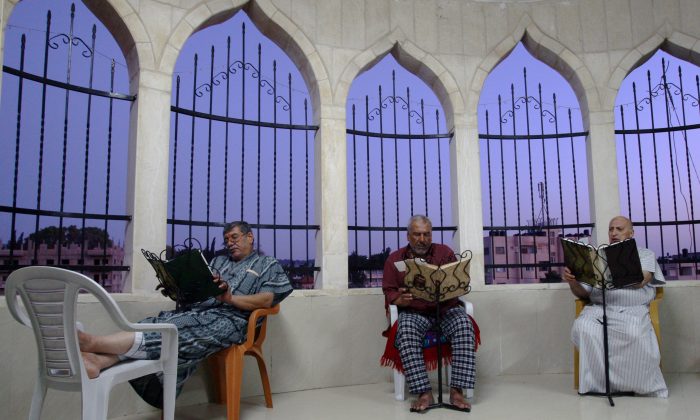 Palestinian Muslims read verses of the Quran, the Muslim holy book, during the early morning prayer, during the Muslim holy fasting month of Ramadan at a mosque in the West Bank refugee camp of Jenin on Friday, July 4, 2014. (AP Photo/Mohammed Ballas)