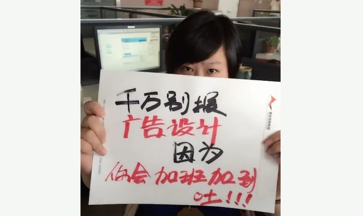 A Chinese college graduate holds a handmade poster saying: "Don't enroll in Advertising Design — you'll throw up due to too much overtime." (Screenshot/Weibo.com)