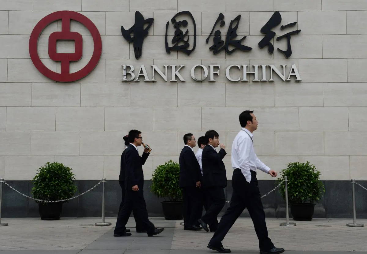 Bank workers walk outside the headquarters of the Bank of China in the Xidan District of Beijing on May 8, 2013. The state-owned Bank of China was accused of money laundering by Party mouthpiece Chinese Central Television on July 9. (Mark Ralston/AFP/Getty Images)