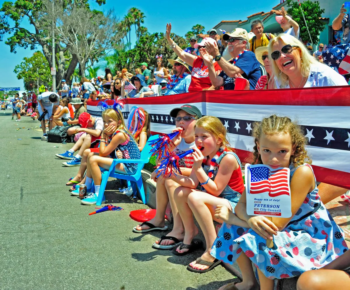 Families watch the Huntington Beach Independence Day Parade in Huntington Beach, Calif., on July 4, 2014. (Eric Zhang/The Epoch Times)