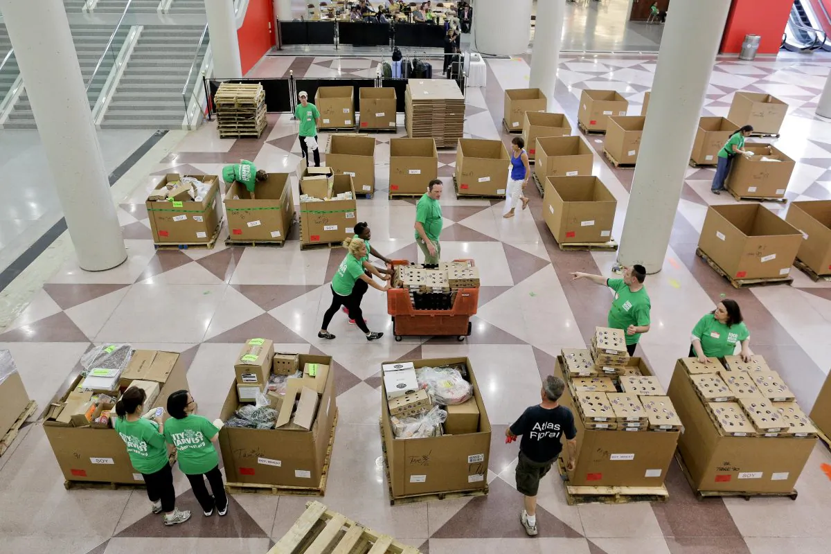 City Harvest volunteers consolidate for loading perishable items, which were donated by exhibitors at the end of the Summer Fancy Food Show convention on July 1. (Julie Jacobson/AP)