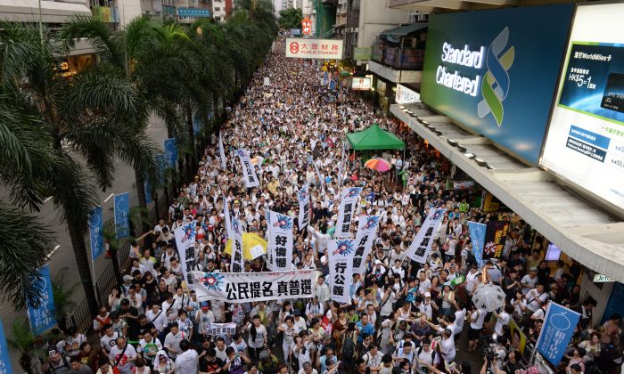 A mass of protesters march through Hong Kong's streets in support of universal suffrage on July 1. The march has become a tradition since 2003, when communist authorities in China attempted to pass a controversial anti-sedition law. (Song Xianglong/Epoch Times) 