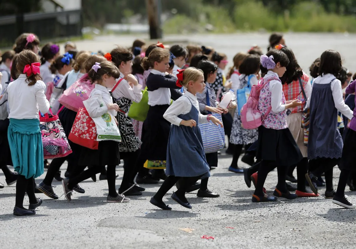 Girls walk to waiting buses after summer day camp in Kiryas Joel, N.Y., on July 1, 2014. (Mike Groll/AP)
