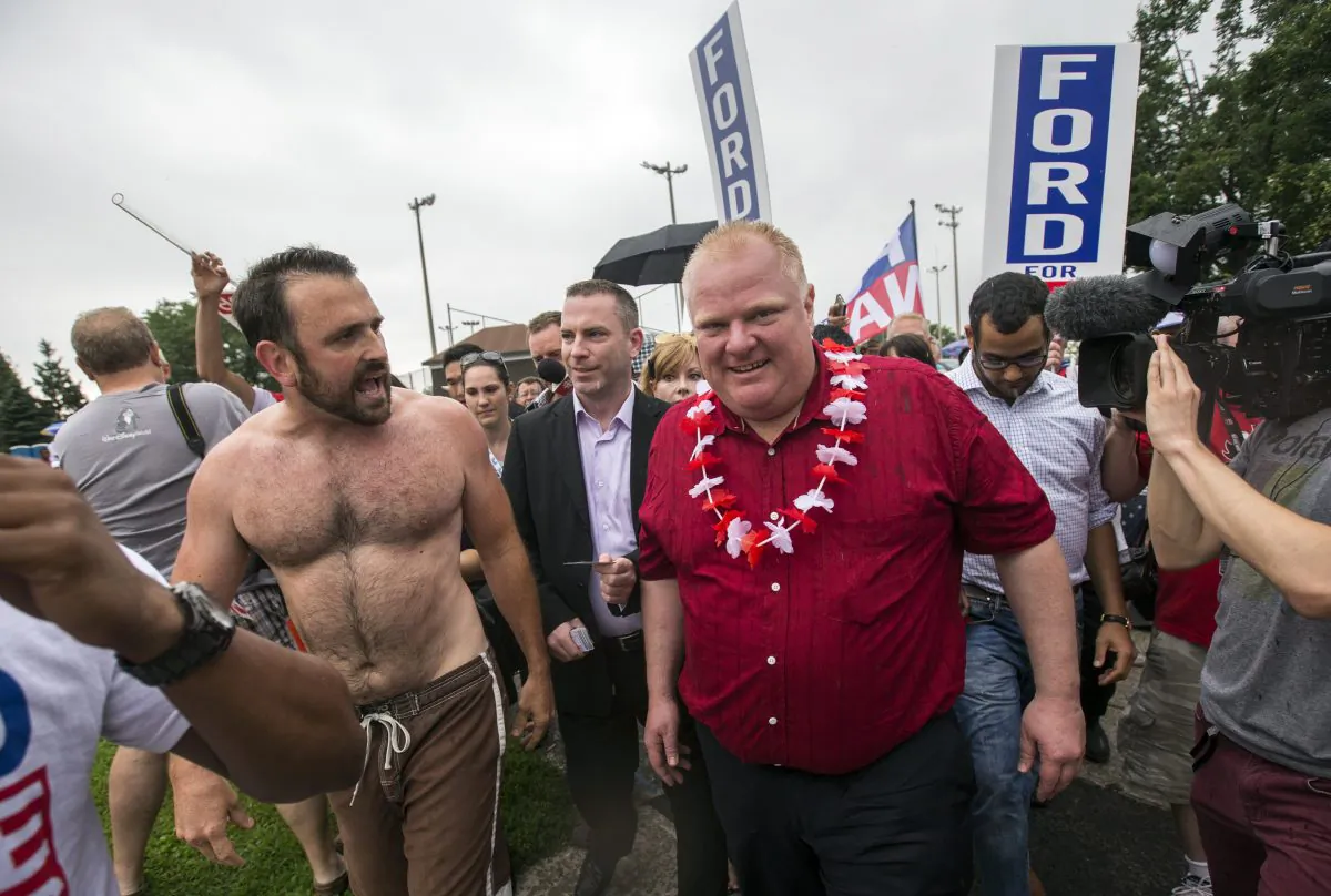 Shirtless teacher Joe Killoran yells at Toronto Mayor Rob Ford as Ford takes part in the East York Canada Day Parade in his first public appearance since returning from a rehabilitation clinic for substance abuse problems. Ford, who shot to prominence last year after admitting to smoking crack, buying illegal drugs, and driving after drinking, has now returned to office and the campaign trail. (REUTERS/Mark Blinch)
