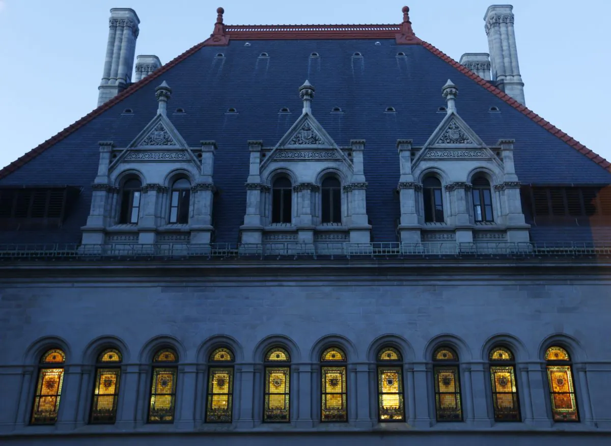 The windows of the Assembly Chamber at the Capitol are illuminated as lawmakers work into the evening on the state budget in Albany, N.Y., March 31, 2014. New York is poised to collect nearly $3.3 billion from a recent record settlement with France’s largest bank. (AP Photo/Mike Groll)