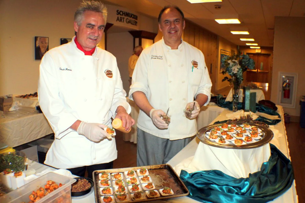 Chuck Moran (Left red collar), General Manager of One Lincoln Square and the Gettysburg Hotel with Chef Joseph Hughes at the Schmukler Gallery preparing amazing treats for guests at the art festival. (Myriam Moran copyright 2014)