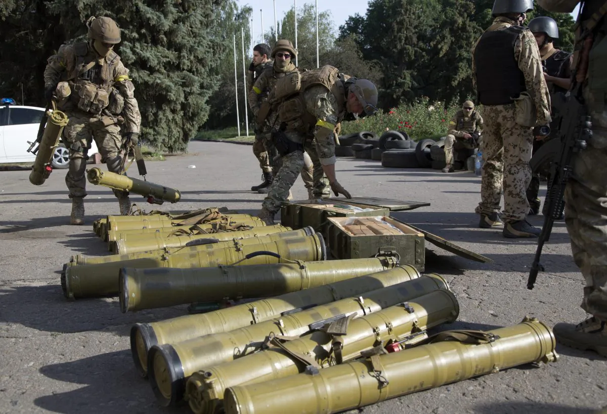 Ukrainian government army soldiers examine weapons captured from rebels in the city of Slovyansk, Donetsk Region, eastern Ukraine on July 5, 2014. By late afternoon on Saturday, Ukrainian troops were fully in control of rebel headquarters in Slovyansk, a city of about 100,000 that has been a center of the fighting between Kiev's troops and the pro-Russia insurgents. (AP Photo/Dmitry Lovetsky)