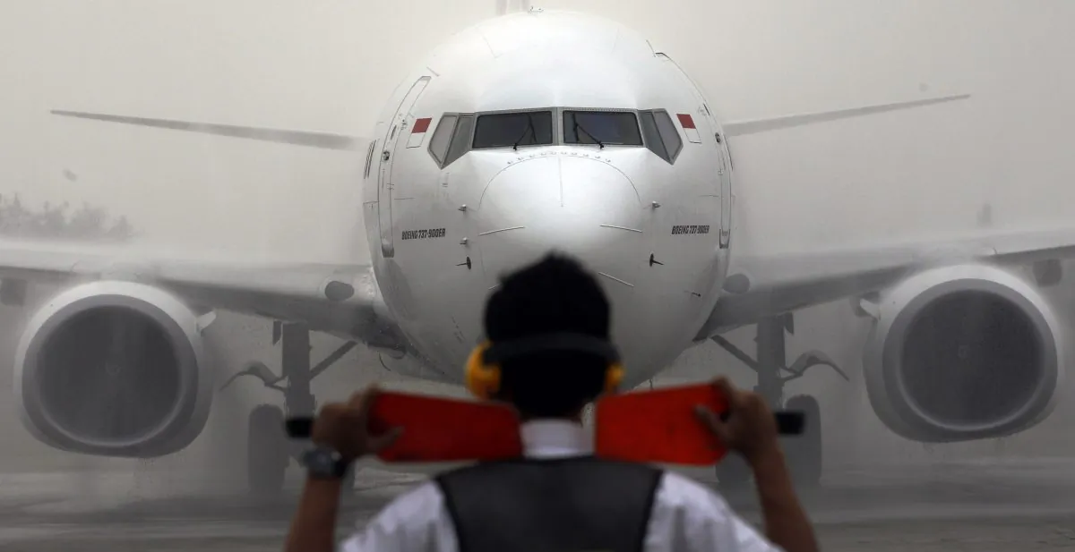 An airport marshal directs a Batik Air jetliner on the tarmac during the launch ceremony of the airline at Soekarno-Hatta International Airport in Jakarta, Indonesia, on April 25, 2013. (Achmad Ibrahim/AP Photo)