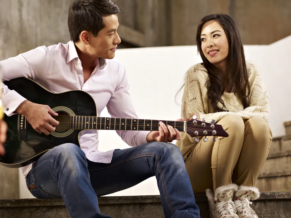 Young people playing guitar and singing. How to understand K-pop? (*Shutterstock)