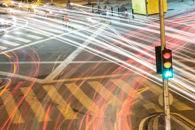 Green drivers swiftly pass a traffic light. *Shutterstock