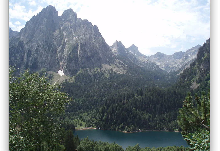 The Enchanted, two emblematic peaks of the Pyrenees and the San Mauricio pond. Encantats in Aigüestortes National Park. Lleida, Spain. (Wikimedia Commons)