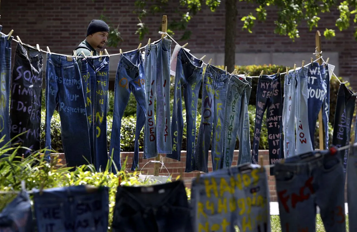 A man looks at blue jeans with messages challenging misconceptions about sexual violence, hung by the UCLA Clothesline Project, on the University of California Los Angeles campus during Denim Day in Los Angeles, Calif., on April 21, 2004 The UCLA Clothesline Project is a student organization which works to stop gender-based violence. In 1999, wearing jeans on Denim Day during Sexual Assault Awareness Month became an international symbol of protest against rape in response to an Italian Supreme Court decision, which overturned a rape conviction because the victim wore jeans. The Italian Court justices reasoned that the victim must have helped her attacker remove her jeans because they believed that without the victim’s help, removing the jeans would be impossible. (David McNew/Getty Images)