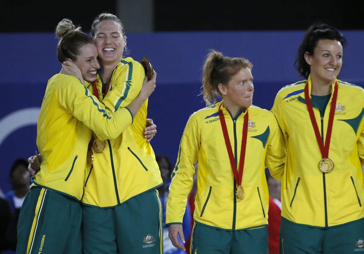 Laura Geitz, left and Caitlin Bassett, of Australia hug after they received their gold medals as they stand on the podium during the medal ceremony, after they defeated New Zealand in the gold medal match in the women's Netball at the Commonwealth Games Glasgow 2014, in Glasgow, Scotland, Sunday, Aug., 3, 2014. (AP Photo/Alastair Grant)