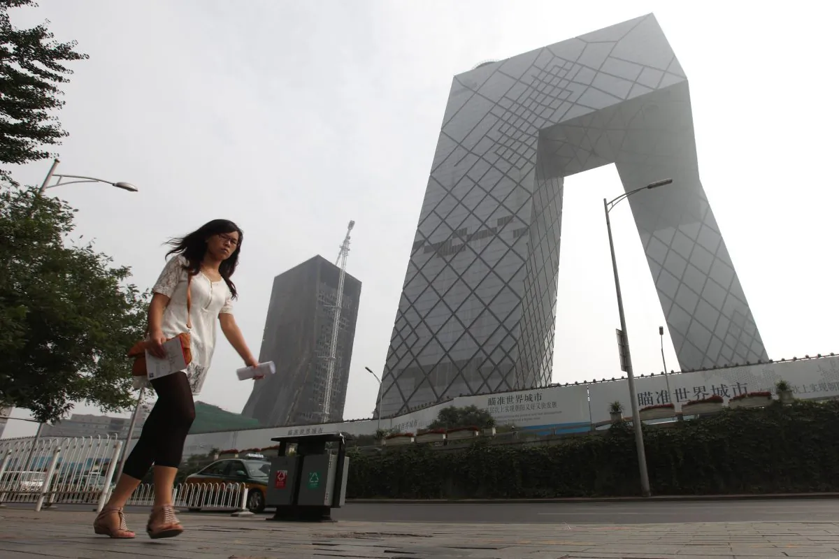 A woman walks pass the China Central Television (CCTV) complex in Beijing on Aug. 13, 2010.  (Franko Lee/AFP/Getty Images) 