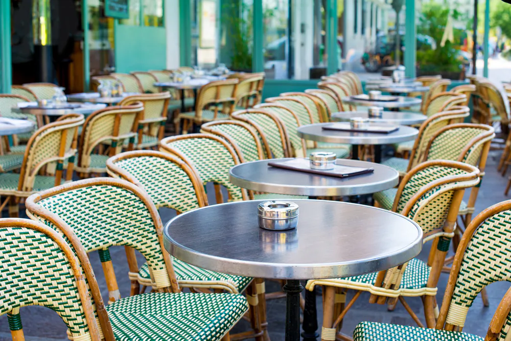 Street view of a coffee terrace with tables and chairs,paris France. (*Shutterstock)
