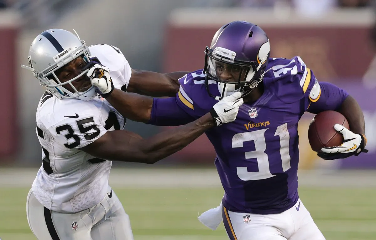 Minnesota Vikings running back Jerick McKinnon (31) stiff-arms Oakland Raiders defensive back Chimdi Chekwa (35) in the first half during a exhibition NFL football game in Minneapolis, Friday, Aug. 8, 2014. (AP Photo/Jim Mone)