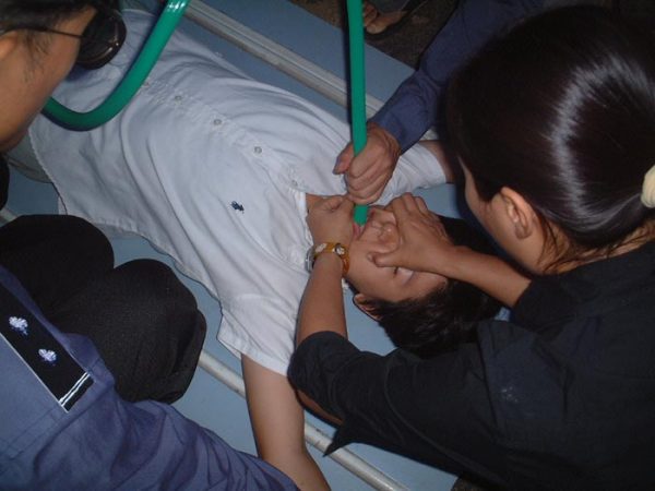 Policemen use a force-feeding torture method on a Falun Gong practitioner at the Hongqiao District Detention Center in Tianjin, China, in this file photo. (Courtesy of Minghui.org)