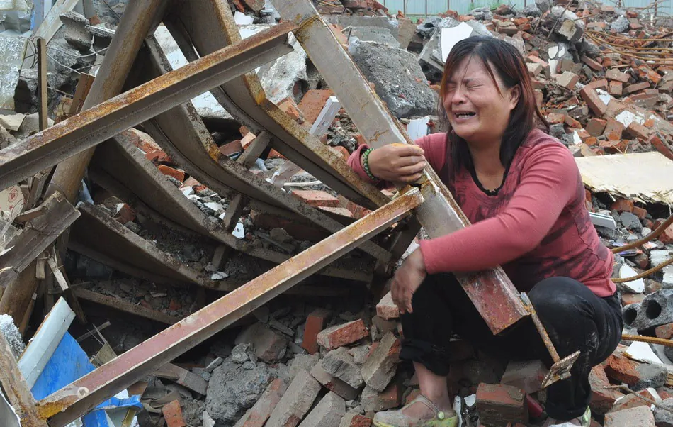 Zhang Hongwei's wife kneels among the rubble of her home and cries, in Xinzheng City of central China’s Henan Province, Aug 8, 2014. Zhang and his wife were kidnapped by a group of anonymous men who burst in on them while sleeping. When the couple was released a few hours later, they found their home was demolished. (Screenshot/163.com)