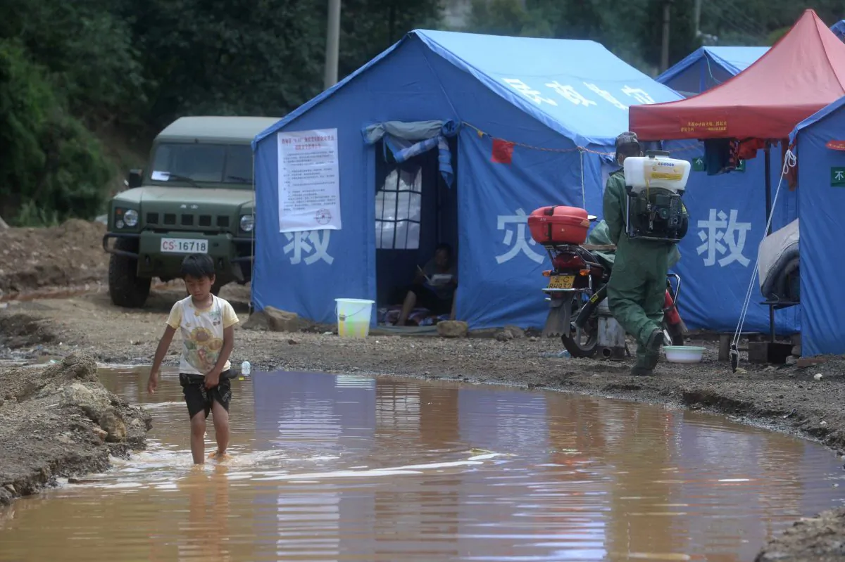 A boy (L) walking through water at a temporary shelter in Longtoushan Township in southwest China's Yunnan province, on Aug. 7, 2014. Local officials are taking advantage of the disaster to gain wealth by selling donated bottled water and food to victims. (AFP/Getty Images)