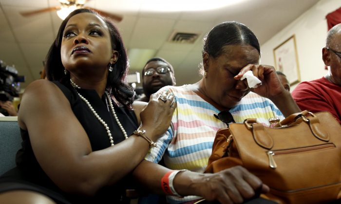 Phaedra Parks, left, comforts Desuirea Harris, the grandmother of Michael Brown, during a news conference Monday, Aug. 11, 2014, in Jennings, Mo. Michael Brown, 18, was shot and killed in a confrontation with police in the St. Louis suburb of Ferguson, Mo, on Saturday, Aug. 9, 2014.(AP Photo/Jeff Roberson)