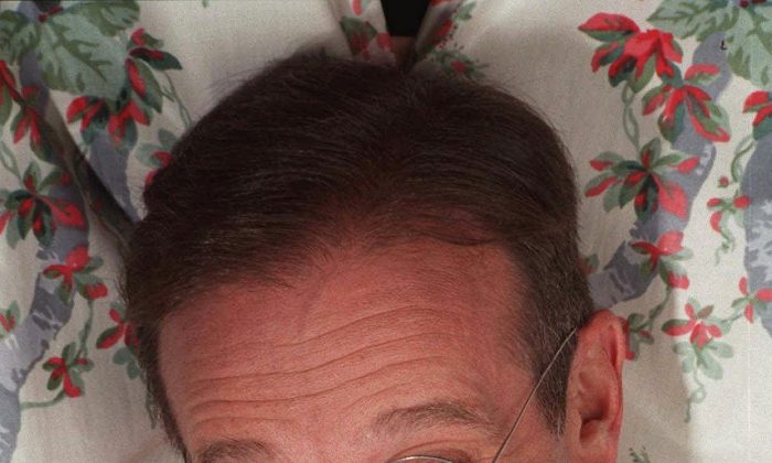 Robin Williams extends his head between curtains in a New York hotel on Nov. 15, 1997. Williams died Monday in an apparent suicide. He was 63. (AP Photo/Jim Cooper)