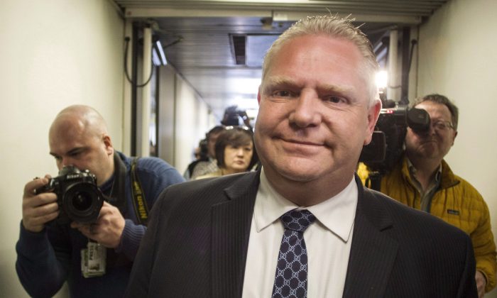 Councillor Doug Ford, Toronto Mayor Rob Ford's brother, makes his way past waiting journalists at City Hall on Feb. 23, 2014. The councillor's public apology to Toronto police Chief Bill Blair for comments made earlier this month came two days after Blair filed a defamation notice against him. Blair has not accepted the apology. (The Canadian Press/Chris Young)