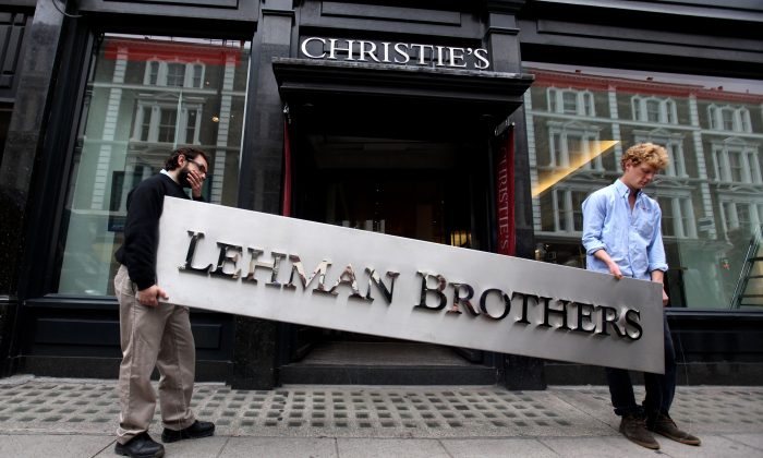 Two employees of Christie's auction house maneuver the corporate logo of the collapsed investment bank Lehman Brothers in London, England, on Sept. 24, 2010. (Oli Scarff/Getty Images)