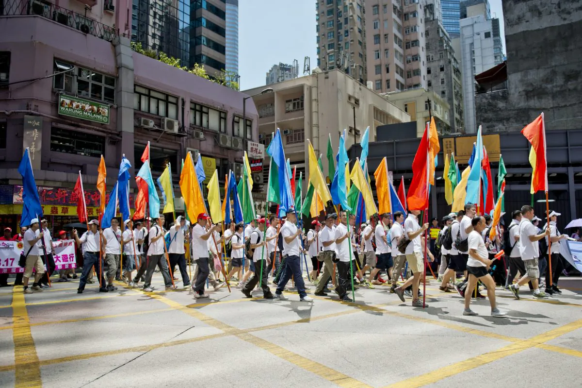 People carry flags as they take part in a Beijing-organized rally in Hong Kong on Aug. 17, 2014. Thousands were brought in from China to protest against the demand for democracy in Hong Kong. (Alex Ogle/AFP/Getty Images)