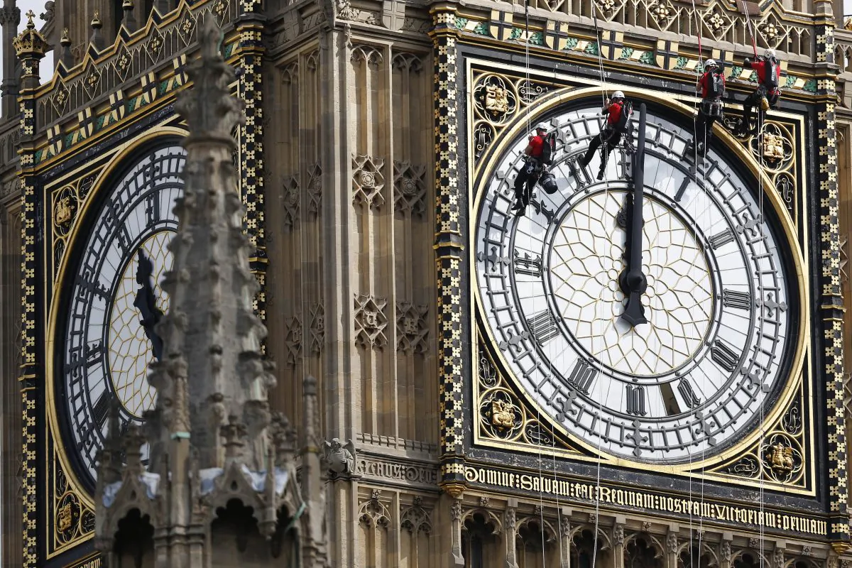 Workers hang outside the clock face as they clean the Big Ben clock tower of the Houses of Parliament in London, Aug. 18, 2014. (AP Photo/Sang Tan)
