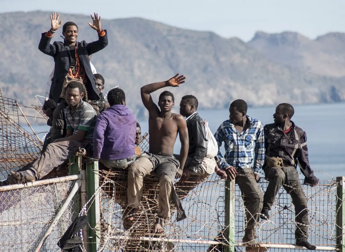 A group of people climbing the fence that separates the borders of Morocco and the Spanish territory of Melilla in an attempt to migrate to Spain, on April 3, 2014. (Blasco Avellaneda/AFP/Getty Images)