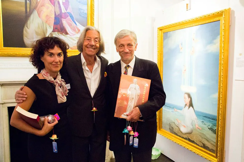 Organiser Joy Felix (L) and Zek Halu, a long time supporter of the Exhibition, (R) with Elio D'Anna, President and Founder of European School of Economics, standing next to his favourite painting "In Harmony" at The Art of Zhen, Shan, Ren (Truth, Compassion, Tolerance) International Exhibition Private View at Il Bottaccio in London on August 6, 2014. (Simon Gross/The Epoch Times). 