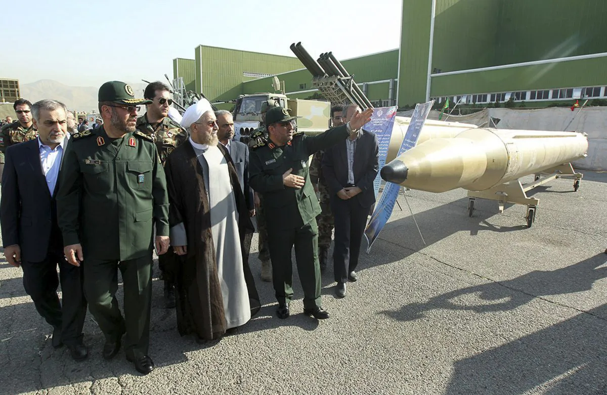 In this photo released by the official website of the office of the Iranian Presidency, Iran's President Hassan Rouhani, center left, visits a defense industry display while listening to explanation of a military official in Tehran, Iran, Sunday, Aug. 24, 2014. (AP Photo/Mohammad Berno, Iranian Presidency Office)