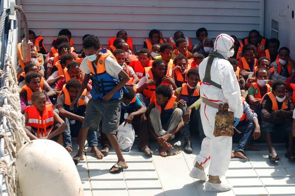 In this Picture released by the Italian Navy, on Aug. 25, 2014, migrants wait to be boarded on the San Giusto Navy ship, along the Mediterranean sea, off the Sicilian island of Lampedusa, Saturday, Aug. 23, 2014. Italian Interior Minister Angelino Alfano renewed his demand for the European Union to relieve pressure on Italy, which has seen some 100,000 migrants arrive so far this year alone. The country says it spends 9.5 million euros ($13 million) a month to operate the beefed-up air and sea patrols that were launched after more than 360 migrants drowned off the Italian island of Lampedusa last October. "Italy will make its own decisions" if EU partners don't offer assistance, he warned in a tweet. The EU's home affairs commissioner, Cecilia Malmstrom, thanked Italy for its "huge efforts" to save lives and said in a statement she would meet Wednesday with Alfano "to better define priorities and provide assistance." (AP Photo/Italian Navy)