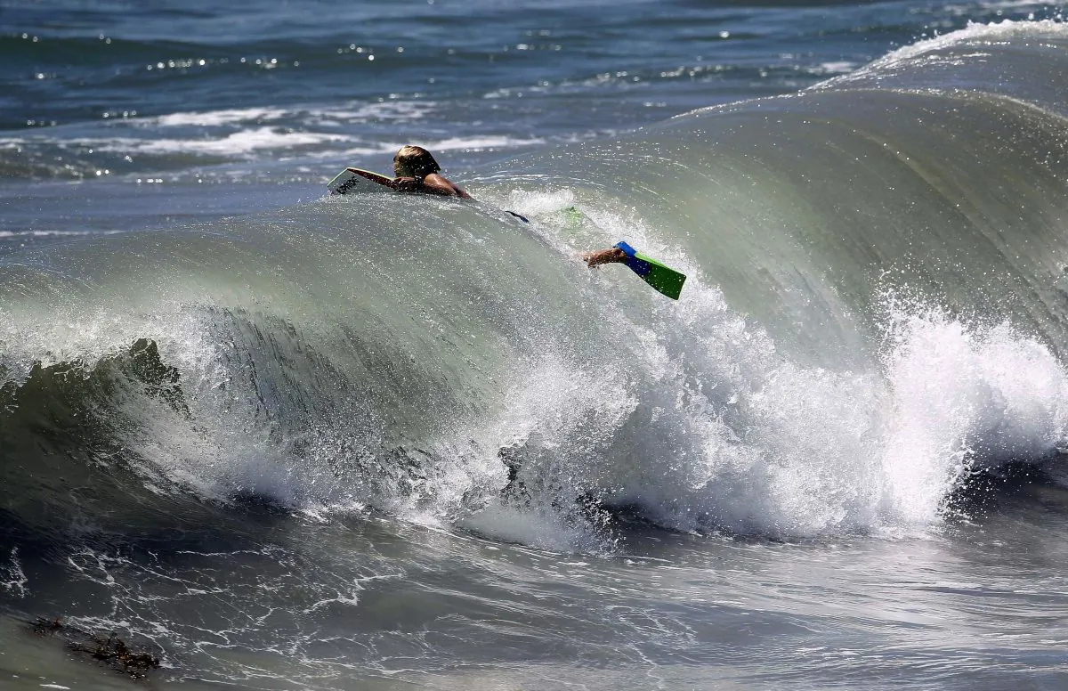 A body surfer swims through a wave in a stock photo. (Nick Ut/AP Photo)